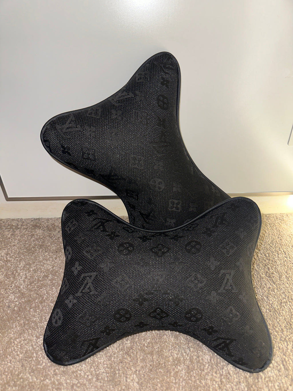 Black patterned car headrest covers on a white and gray background
